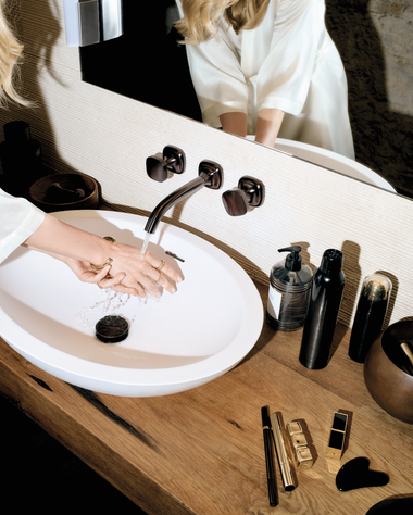 Coya in Dark Bronze gebürstet: Die sanft gerundete Form schafft ästhetische Verbindungen,
wie hier zur geriffelten Natursteinoberfläche.