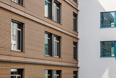 Holz in der Fassade des Neubaus Stationsgebäude Süd des Universitätsklinikums  AKH Wien mit auskragenden Blechen. 