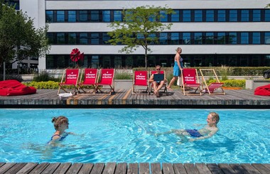 Kurze Abkühlung in der Mittagspause: Mitarbeitende auf dem Campus "Neue Balan" genießen eine Auszeit im Pool.